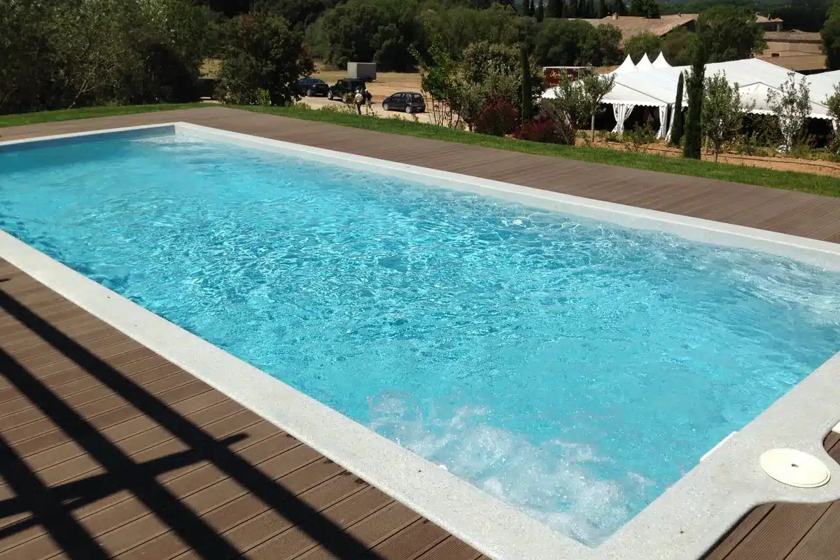 Piscine coque rectangulaire Platinium 7 à fond plat devant une maison