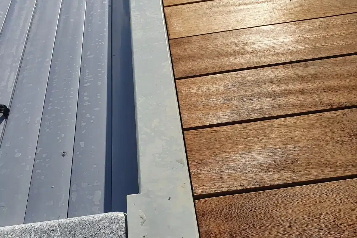 Ligne d'eau d'une piscine coque bordée d'une plage en bois